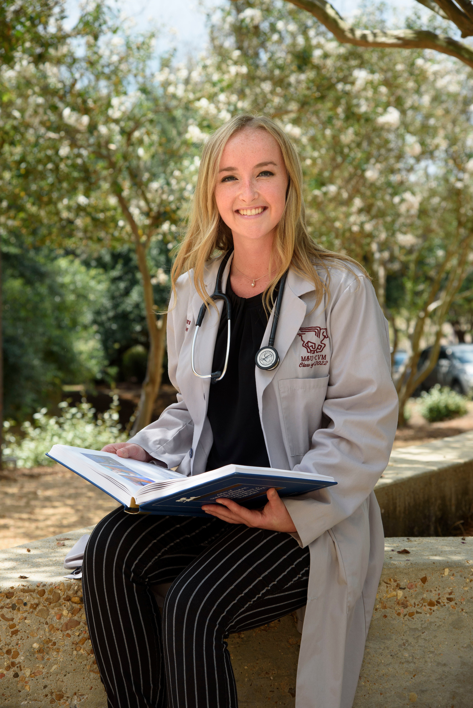 A veterinary student studies outside 